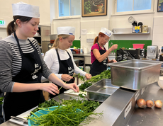Köch*innen im Marienstüberl zupfen Petersilie. 