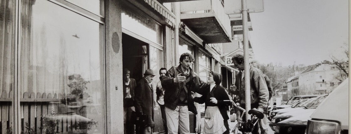 Schwarz-weiß Foto einer Ordensschwester, die vor einer Hausfassasde, dem damaligen Marienstüberl, mit einigen Männern redet. 