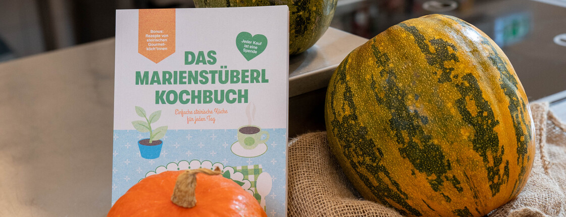 Kürbisse und zwei Marienstüberl-Kochbücher liegen auf. 