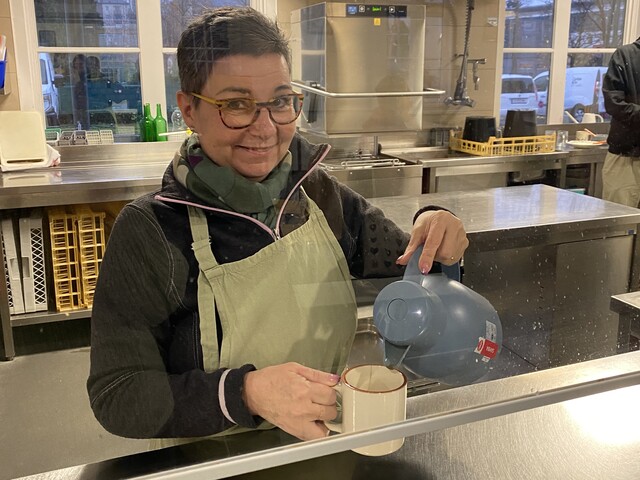Foto der freiwilligen Mitarbeiterin Birgit, auf dem sie Kaffee ausschenkt. 