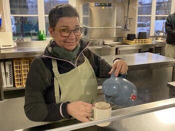 Foto der freiwilligen Mitarbeiterin Birgit, auf dem sie Kaffee ausschenkt. 