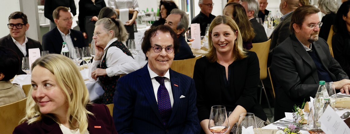 Mehrere Leute sitzen an gedeckten Tischen. Im Fokus sind Saubermann-Geschäftsführer Hans Roth und Caritasdirektorin Nora Tödtling-Musenbichler. 